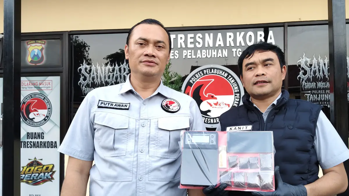 DISITA: Kasatresnarkoba Polres Pelabuhan Tanjung Perak AKP Adik Agus Putrawan (kiri) menunjukkan barang bukti yang disita dari pengedar ganja asal Banyu Urip Kidul, Surabaya. Ia mengaku beli di Instagram. (IST/RADAR SURABAYA)
