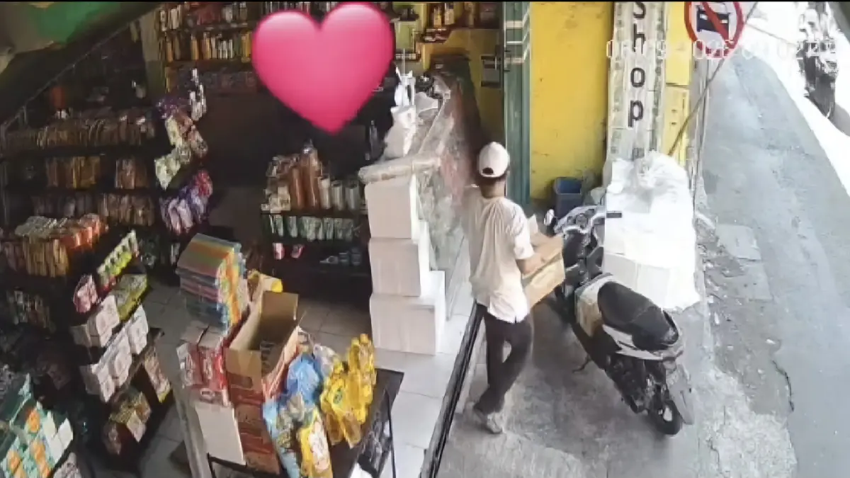 TERPANTAU : Pelaku pencurian dua kardus minyak goreng di toko Jalan Banyu Urip Wetan V, Surabaya, terekam CCTV toko saat membawa kardus minyak ke motor.(IST/RADAR SURABAYA)