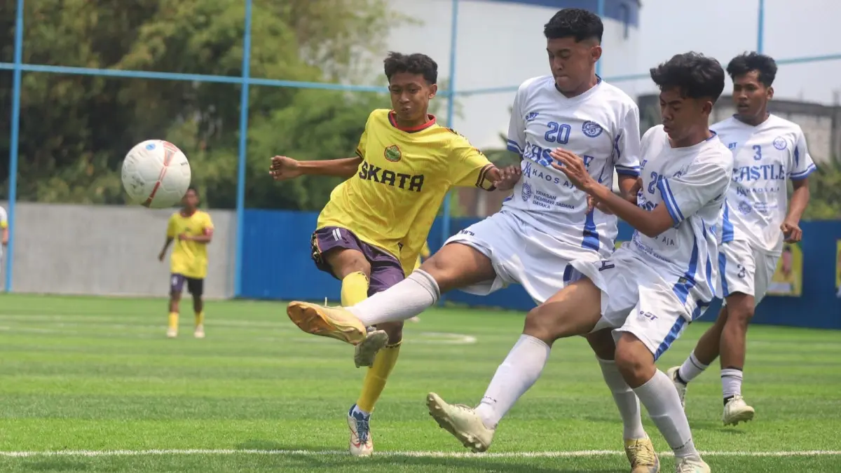 LAGA PERDANA: Dua penggawa SMAN 1 Puri (kostum putih) berusaha merebut bola dari pemain Tamansiswa Mojokerto di laga babak 16 besar. Pertandingan tersebut dimenangkan tim Tamansiswa Mojokerto lewat adu penalti dengan skor 3-2. (SOFAN KURNIAWAN/RADAR MOJOKERTO)
