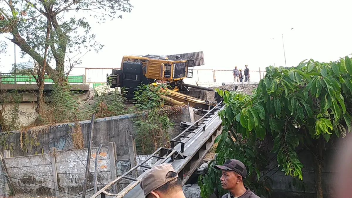 JATUH: Nampak crane yang roboh di Jalan HR Muhammad, Surabaya, saat mengerjakan penguatan lereng Jalan Tol Surabaya - Gempol. (IST/RADAR SURABAYA)