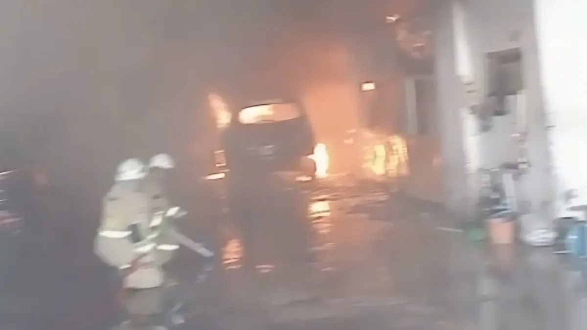 BERJIBAKU: Petugas DPKP Surabaya saat memadamkan kebakaran bengkel mobil di Jalan Siwalankerto, Surabaya. (IST/RADAR SURABAYA)