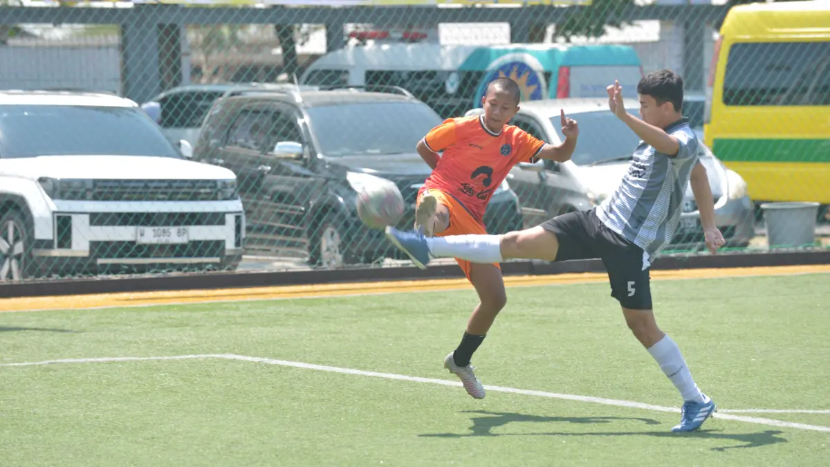 BEREBUT BOLA: Pemain SMA Muhammadiyah 4 Surabaya (kanan) berduel dalam turnamen Bahlil Mini Soccer Surabaya. (ANDY SATRIA/RADAR SURABAYA)