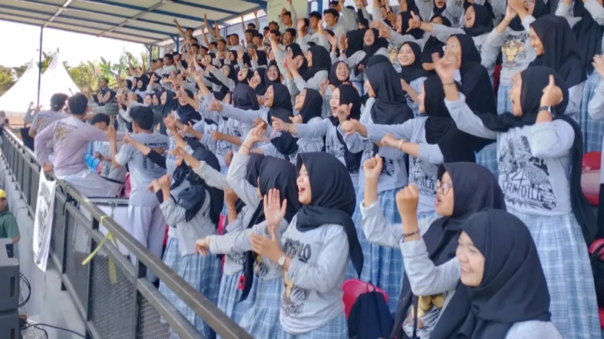 TERBAIK DI TRIBUN: Armadilo, suporter SMA Muhammadiyah 4 Surabaya, tampil penuh energi mengawal perjuangan tim di Turnamen Bahlil Mini Soccer Zona 7 Surabaya.