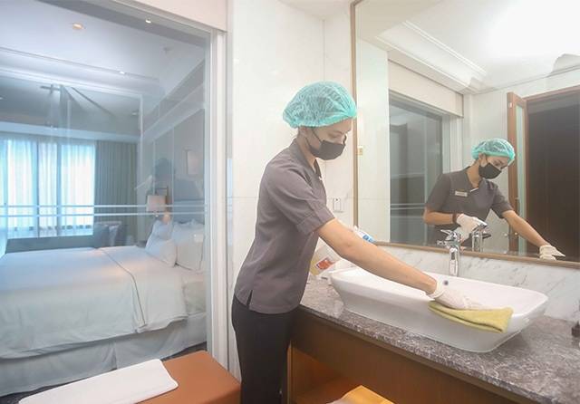 CLEAN: Petugas hotel membersihkan wastafel kamar untuk memastikan kebersihan dan keamanan tamu. (DOK/JAWAPOS)