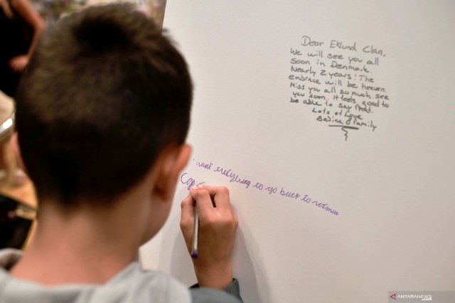 Seorang anak menuliskan pesan di papan ucapan, sebagai bagian dari pameran proyek COVID-19 Museum Pos, di O2 Arena, di London, Inggris. (ANTARA/REUTERS)