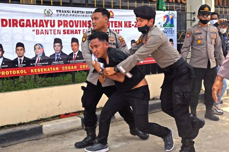 Sejumlah anggota polisi mengamankan pedemo saat membubarkan aksi unjuk rasa memprotes ketimpangan pembangunan di Banten yang berlangsung di depan Gedung DPRD Banten di Serang, Senin (4/10/2021). (ANTARA)
