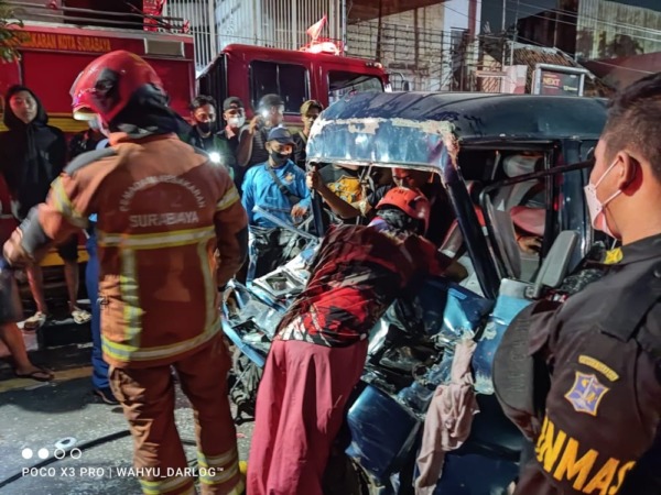 Petugas mengevakuasi pengemudi mobil yang terjepit akibat kecelakaan di Kapasari, Surabaya. (IST)