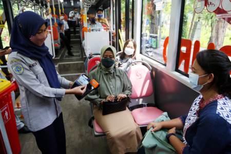 Kru Suroboyo Bus mensosialisasikan e-payment sebagai pembayaran tiket Bus Suroboyo kepada penumpang di Terminal Intermoda Joyoboyo, Senin (11/10).