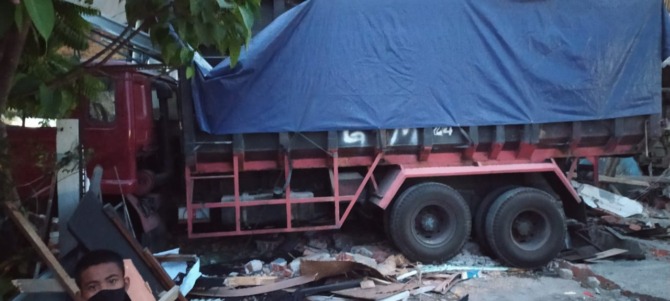 RINGSEK: Kondisi truk bermuatan jagung yang menabrak teras rumah warga di Jalan Mastrip, Karang Pilang. (IST)