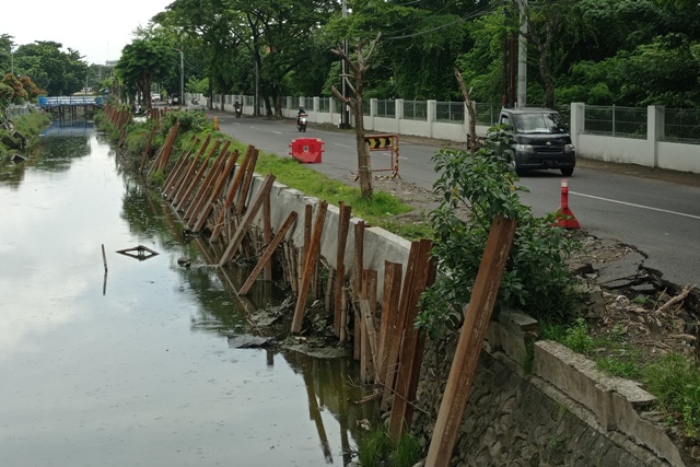 DIPERBAIKI: Kendaraan bermotor melintas tak jauh dari plengsengan sungai yang ambrol di Jalan Arif Rahman Hakim, Surabaya. (SURYANTO/RADAR SURABAYA)