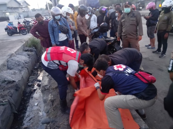 Petugas mengevakuasi pengendara motor yang tewas di Jalan Greges, Asemrowo, Surabaya. (IST)