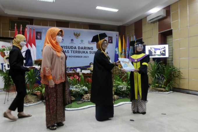 BERI PENGHARGAAN: Direktur UT Surabaya, Hj Suparti, M.Pd, memberikan penghargaan kepada wisudawan terbaik, Linda Kurniawati, dalam wisuda UT Surabaya tahun 2021.2, di kampus setempat, Selasa (23/11).