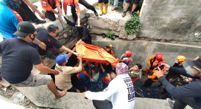 DIEVAKUASI: Petugas mengangkat jenazah korban Galang Suryo Aji Yulianto. (MAHRUS/RADAR SURABAYA)