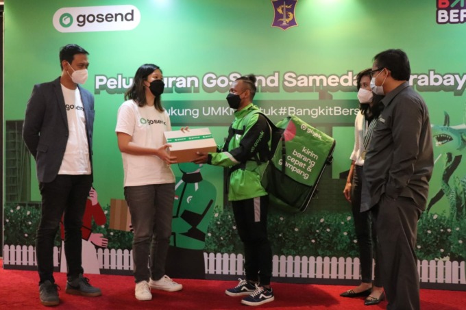 SIMBOLIS: Dena Natalia, District Head Gojek Surabaya Raya saat memberikan box barang kepada driver GoSend untuk dikirim ke alamat tujuan. (LUKMAN AL FARISI/RADAR SURABAYA)