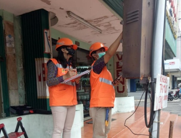 BERKALA: Petugas PLN sedang mengecek pemakaian angka kWh meter yang terpasang di pelanggan. (ISTIMEWA)