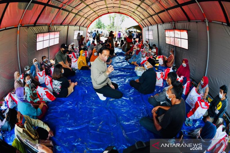 Presiden Jokowi meninjau posko pengungsi di Lapangan Desa Sumberwuluh, Kabupaten Lumajang, Jawa Timur pada Selasa (7/12/2021). (ANTARA)