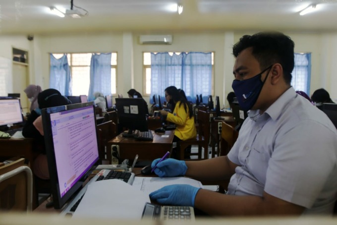 UJIAN SERENTAK: Mahasiswa Universitas Terbuka (UT) Surabaya, mengikuti Ujian Tugas Akhir Program (TAP) yang dilakukam secara online, di SMKN 5 Surabaya, Sabtu (18/12). (ANDY SATRIA/RADAR SURABAYA)