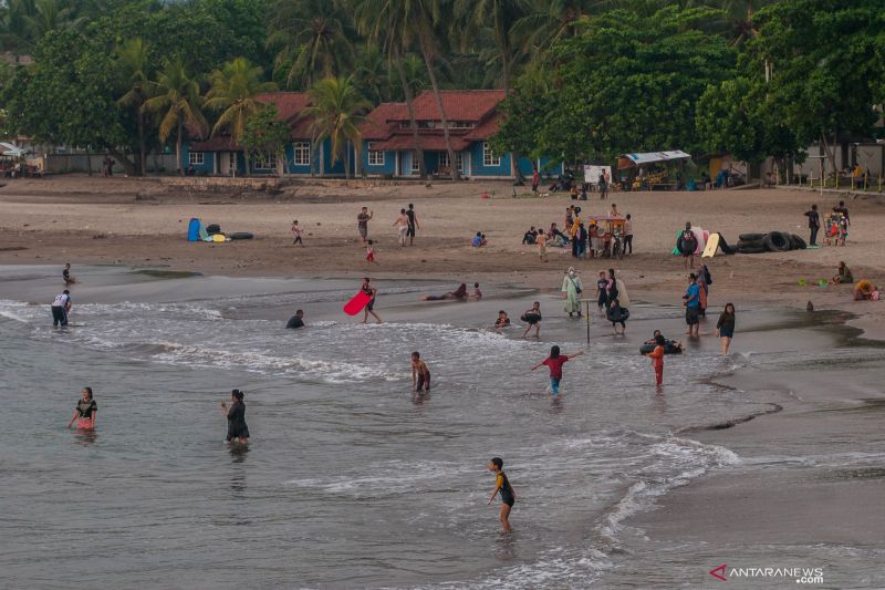 Pengunjung bermain air di Pantai Carita, Pandeglang, Banten, Minggu (26/9/2021). (ANTARA)