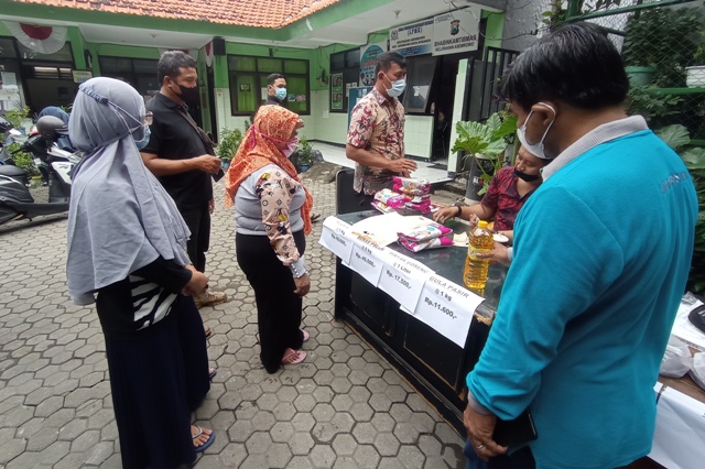 TERTIB DAN SABAR: Sejumlah warga antre membeli sembako saat operasi pasar di kantor Kelurahan Asemrowo, Surabaya, Jumat (3/12).  (SURYANTO/RADAR SURABAYA)