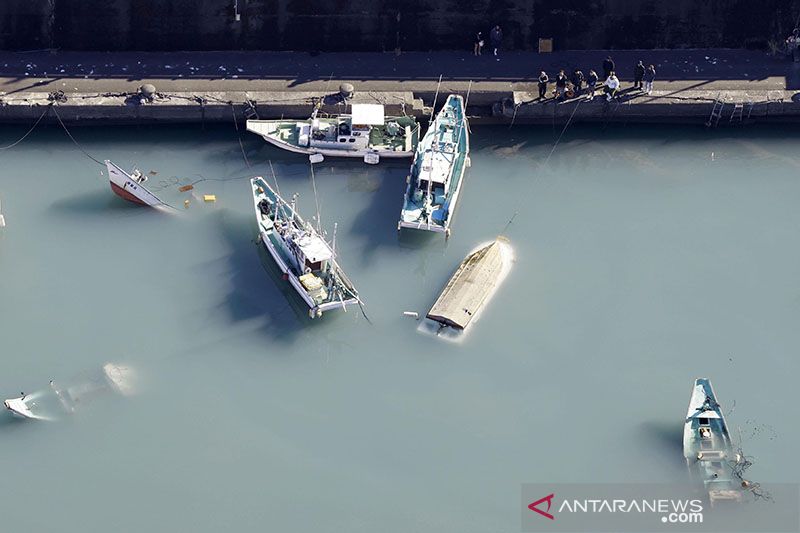 Foto diambil Minggu, 16 Januari 2022, dari helikopter Kantor Berita Kyodo, memperlihatkan perahu dan kapal terbalik dan sebagian tenggelam di pelabuhan Muroto di Prefektur Jepang barat, setelah pantai Pasifik negara itu dilanda tsunami. (Kyodo via Reuters
