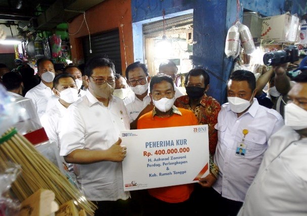 SIMBOLIS: Menteri Koordinator Bidang Perekonomian, Airlangga Hartarto menyerahkan KUR kepada pedagang didampingi Direktur Hubungan Kelembagaan BNI Sis Apik Wijayanto di Pasar Wonokromo Surabaya. (ABDULLAH MUNIR/RADAR SURABAYA)
