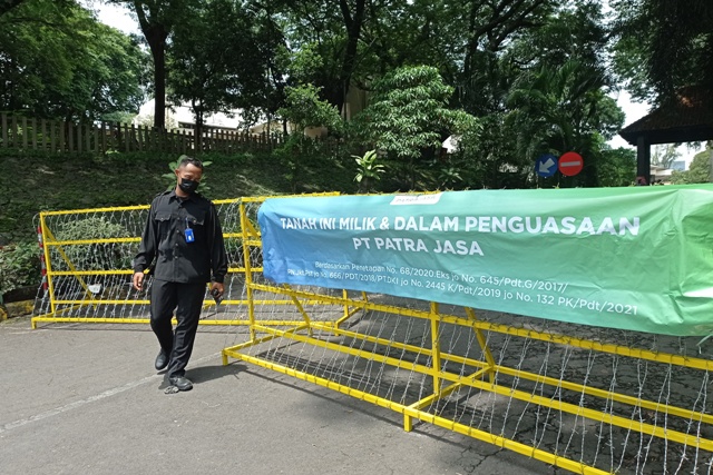 ANTISIPASI: Petugas keamanan berjaga di gerbang Hotel Singgasana, kawasan Gunungsari, Surabaya, Selasa (18/1). (SURYANTO/RADAR SURABAYA)