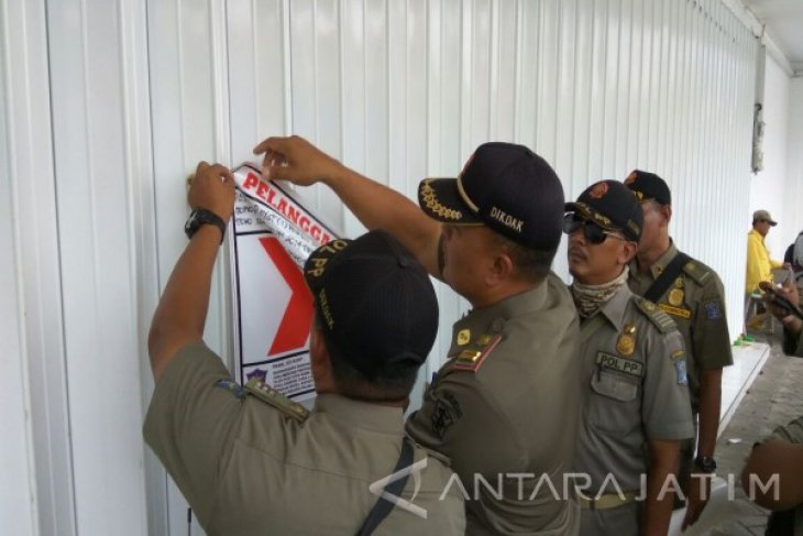 TEGAS: Petugas Satpol PP menyegel salah satu minimarket di Surabaya beberapa waktu lalu. (ANTARA)