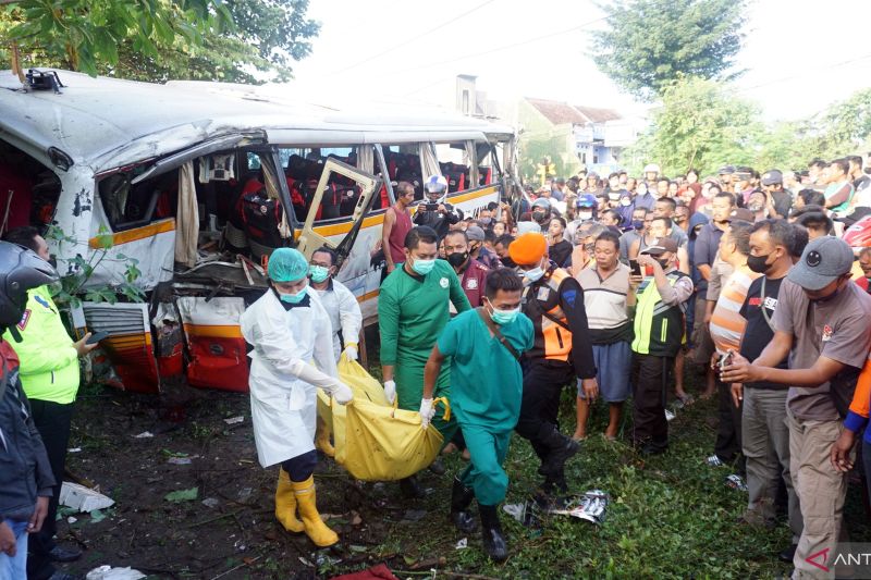 Petugas mengevakuasi korban kecelakaan bus pariwisata PO Harapan Jaya yang tertabrak KA Rapih Doho di perlintasan kereta api tanpa palang pintu di Desa Ketanon, Tulungagung, Jawa Timur, Ahad (27/2/20). Kecelakaan yang terjadi sekitar pukul 05.00 WIB itu m