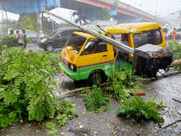 RINGSEK: Salah satu tiang PJU tumbang menghantam angkot di kawasan Wonokromo, Surabaya. (ABDULLAH MUNIR/RADAR SURABAYA)