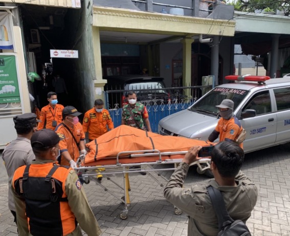 AJAL SAMPAI: Petugas mengevakuasi jenazah penghuni kos untuk dibawa ke RSUD dr Seotomo Surabaya. (IST)
