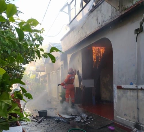 Petugas PMK berusaha memadamkan api di kawasan Kupang Gunung, Surabaya. (IST)