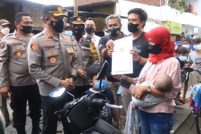 PEDULI OJOL: Kapolrestabes Surabaya Kombes Pol Akhmad Yusep menyerahkan bantuan motor dari Jokowi kepada korban curanmor di kawasan Wiyung, Surabaya, Senin (14/2). (SURYANTO/RADAR SURABAYA)