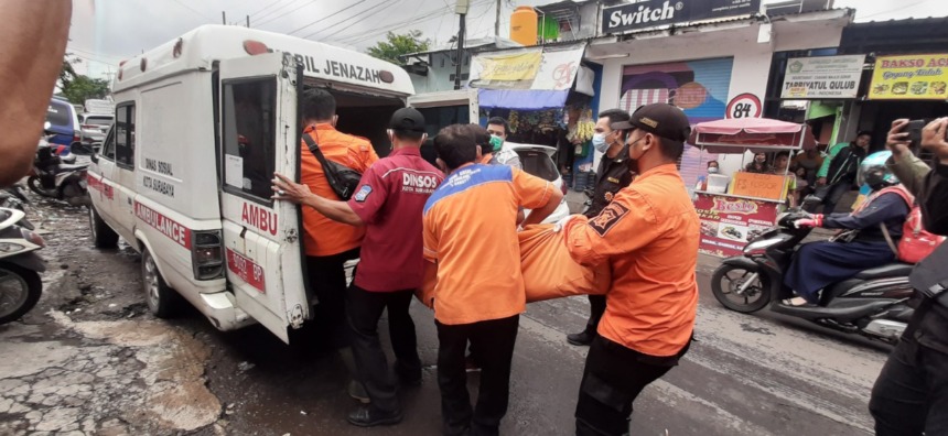 Petugas mengevakuasi jenazah pasien panti pijat di Petemon Barat, Surabaya. (MAHRUS/RADAR SURABAYA)