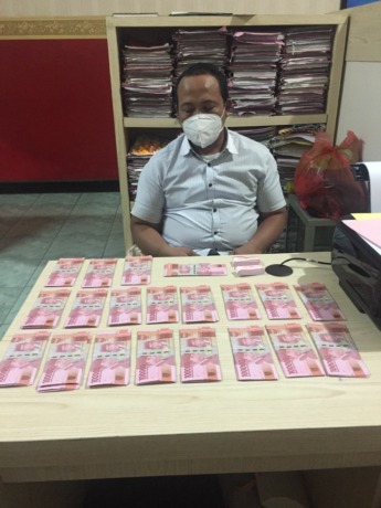 DIAMANKAN: Pengedar uang palsu ditahan bersama barang bukti di Polrestabes Surabaya. (IST)