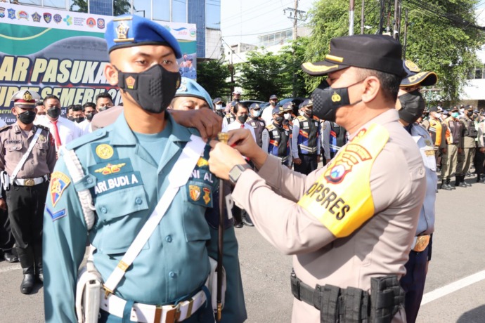 SINERGI: Kapolres Pelabuhan Tanjung Perak AKBP Anton Elfrino Trisanto menyematkan tanda pengenal kepada anggota TNI AL saat gelar pasukan, Jumat (22/4) pagi. (IST)