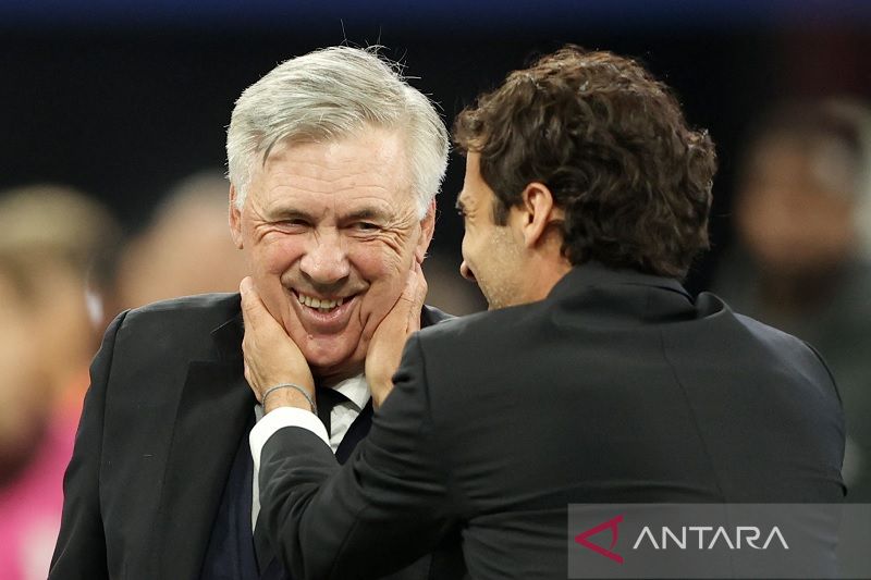 Manajer Real Madrid Carlo Ancelotti (kiri) diselamati oleh legenda Los Blancos Raul Gonzalez seusai menjuarai Liga Champions 2021-22 dengan mengalahkan Liverpool di Stade de France, Saint-Dennis, Paris, Prancis, Sabtu (28/5/2022) waktu setempat. (ANTARA/R