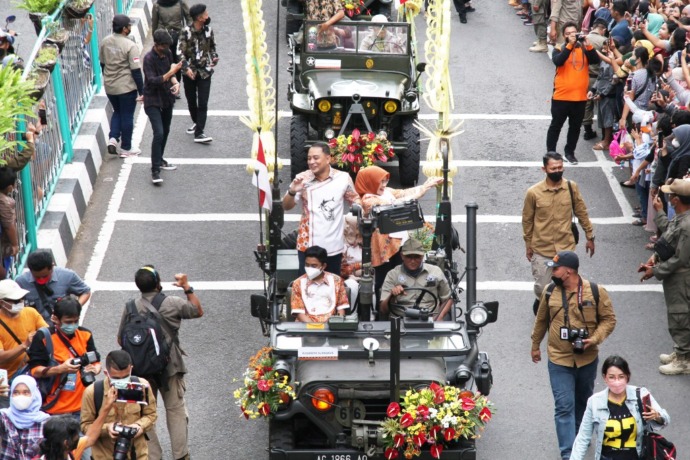 ANTUSIAS: Wali Kota Surabaya Eri Cahyadi menyapa ribuan warga saat pawai mobil hias Surabaya Vaganza di Jalan Tunjungan, Surabaya, Sabtu (28/5).  (SURYANTO/RADAR SURABAYA)