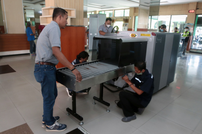 PASANG X-RAY: Petugas PT Angkasa Pura 1 menurunkan alat pemeriksaan X-ray untuk memeriksa barang bawaan CJH di Asrama Haji Sukolilo, Kamis (2/6).  (ANDY SATRIA/RADAR SURABAYA)