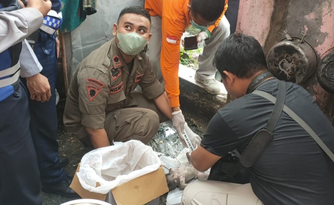 EVAKUASI: Petugas gabungan mengevakuasi jenazah bayi di Jemur Ngawinan I, Surabaya, Rabu (8/6). (IST)