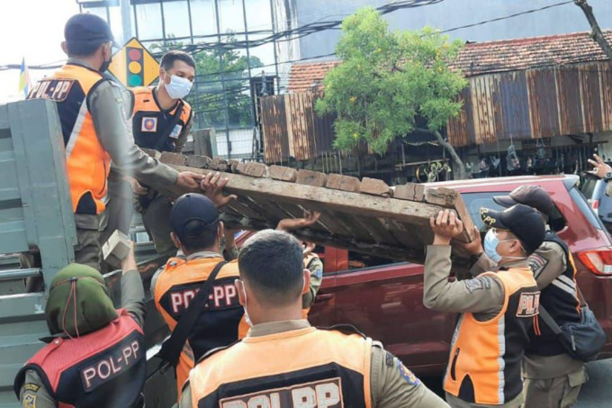RAZIA PKL: Petugas Satpol PP Kota Surabaya menertibkan pedagang kaki lima (PKL) di kawasan Jalan Gembong, Surabaya. (SURYANTO/RADAR SURABAYA)
