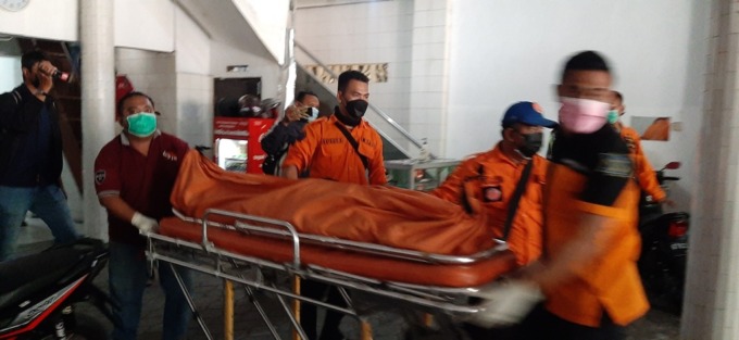 MENCURIGAKAN: Petugas mengevakuasi jenazah Sofiah di Jalan Pasar Kembang Nomor 16, Surabaya. (MAHRUS/RADAR SURABAYA)