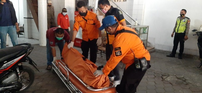 MENGAGETKAN: Petugas menggotong kantong mayat korban Sofiah di Jalan Pasar Kembang Nomor 16, Surabaya.  (MAHRUS/RADAR SURABAYA)