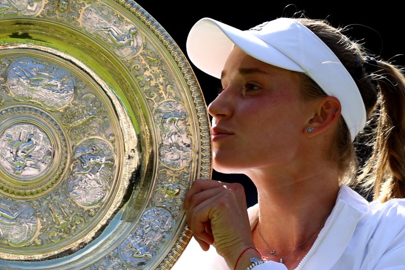 Petenis Kazakhstan Elena Rybakina mengangkat trofi juara tunggal putri Wimbledon 2022 setelah mengelaahkan petenis Tunisia Ons Jabeur dalam final di All England Lawn Tennis and Croquet Club, London, Inggris, 9 Juli 2022. (REUTERS/HANNAH MCKAY)
