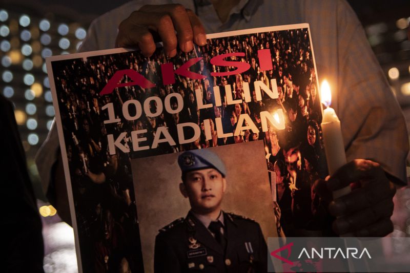 Peserta aksi dari Tim Advokat Penegakan Hukum dan Keadilan (TAMPAK) memegang poster saat aksi seribu lilin dan doa bersama untuk Brigadir Yosua Hutabarat di Bundaran HI, Jakarta, Jumat (22/7/2022). (ANTARA)