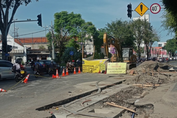 SOLUSI BANJIR: Pengendara melintas tak jauh dari pengerjaan proyek gorong-gorong di Jalan Gubernur Suryo, Surabaya, Senin (25/7). (SURYANTO/RADAR SURABAYA)