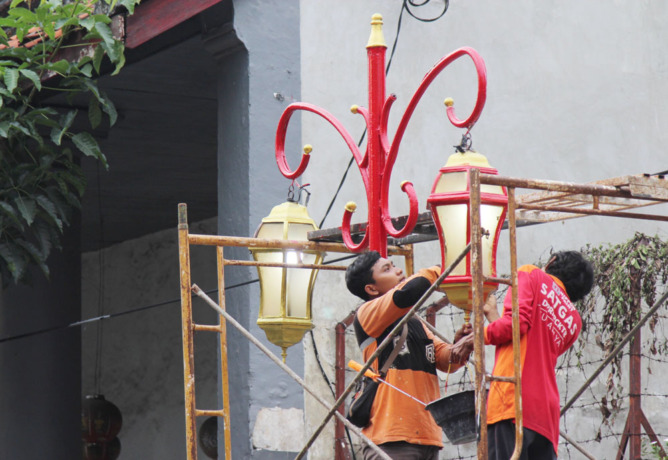 MERAH KHAS TIONGHOA: Satgas dari DPRPCKTR sedang melakukan mockup pengecatan lampu penerangan di Jalan Karet, Rabu (6/7). (ABDULLAH MUNIR/RADAR SURABAYA)