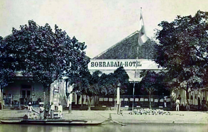 KENANGAN: Foto Soerabaia Hotel dengan bendera merah putih biru di depannya karya fotografer Herman Salzwedel yang diambil tahun 1876. (ISTIMEWA/KITLV)