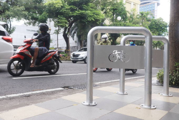 Pengendara melintas tak jauh dari fasilitas parkir sepeda yang tersedia di Jalan Tunjungan, Surabaya. (SURYANTO/RADAR SURABAYA)