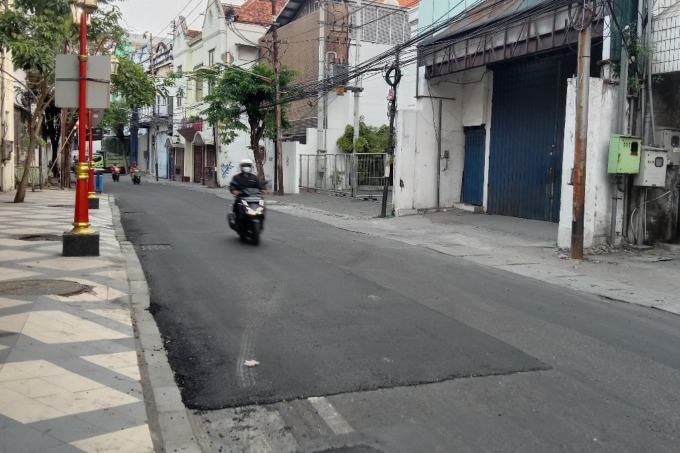 MAKIN LANCAR: Pengendara kendaraan bermotor melintasi jalan dengan aspal baru di Jalan Karet, Surabaya, Jumat (5/8). (SURYANTO/RADAR SURABAYA)