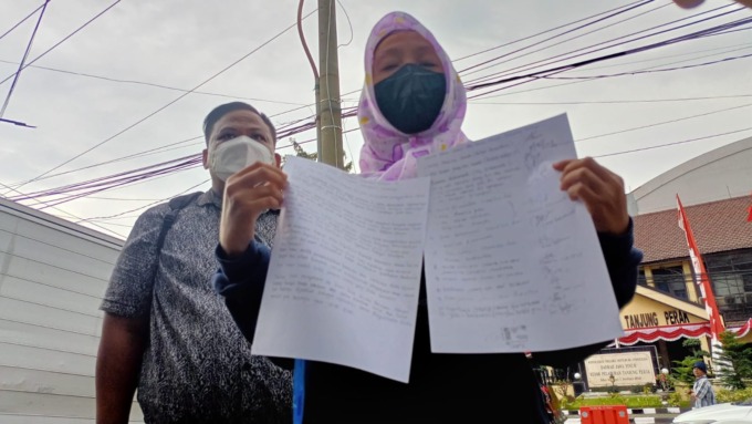 SUDAH DITANGANI: Ajeng Ayunda Putri menunjukkan surat kuasa dari para korban untuk mencabut laporan di Polrestabes Surabaya. (IST)